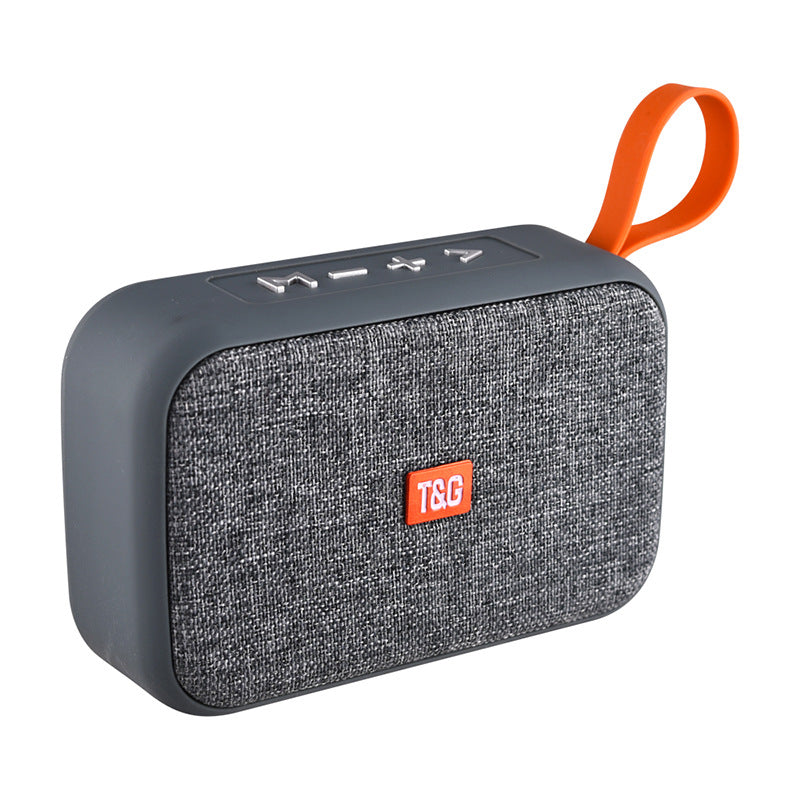 Gray portable speaker with an orange handle and visible brand logo on a white background
