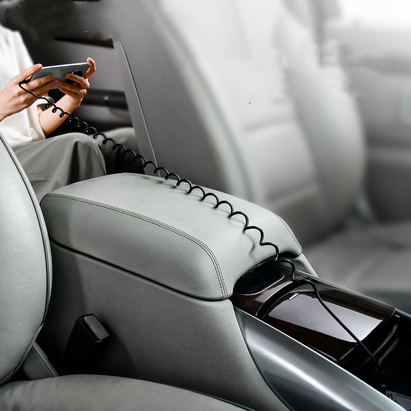 Car interior with a headrest organizer holding a phone and sunglasses.