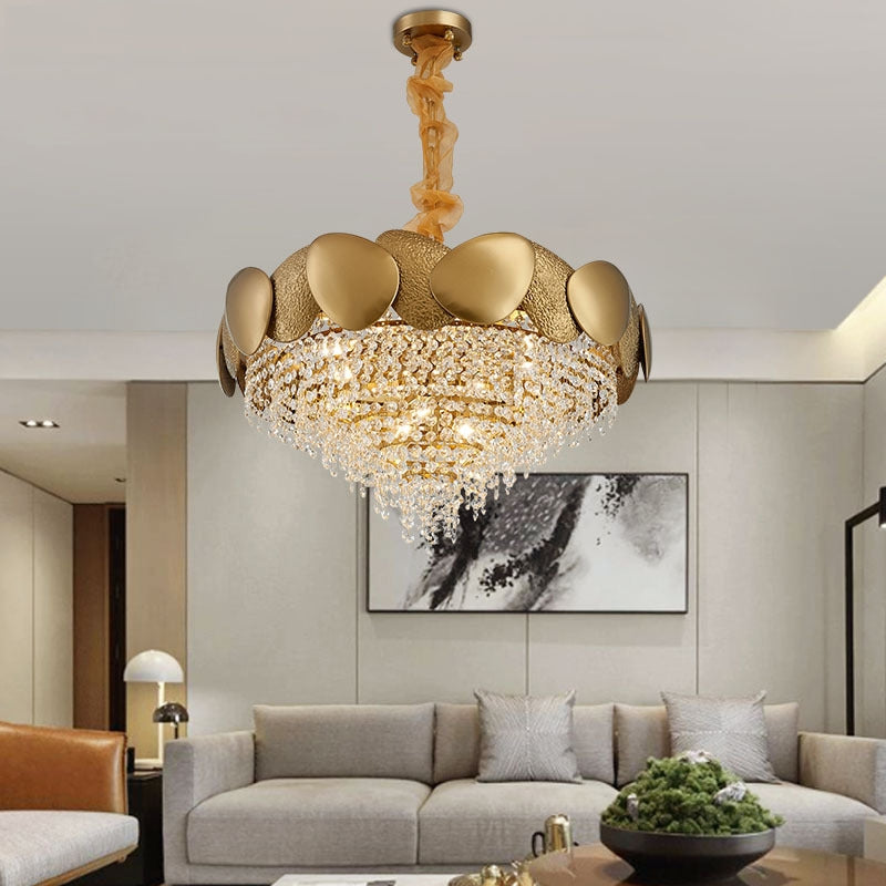 Luxurious gold chandelier in a living room setting with a sofa and decor.