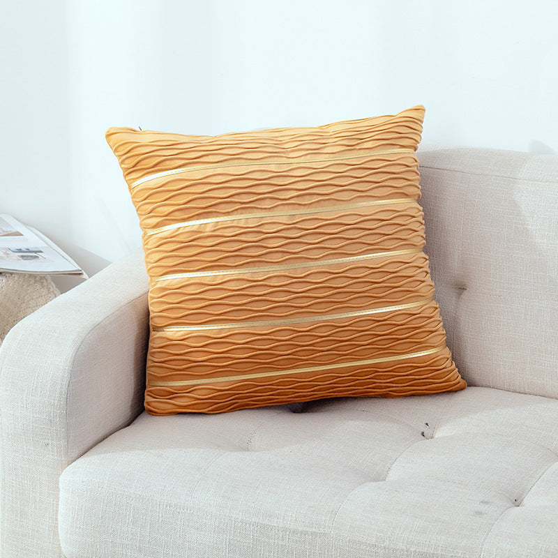 Yellow textured pillow on a beige sofa with a white wall background