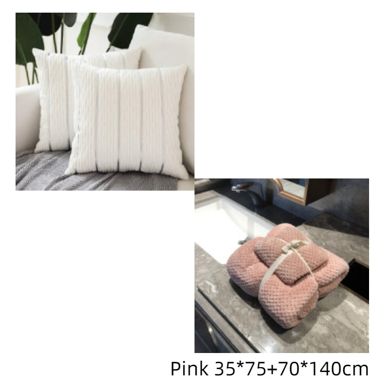 White textured pillows on a sofa and a pink textured blanket on a surface.