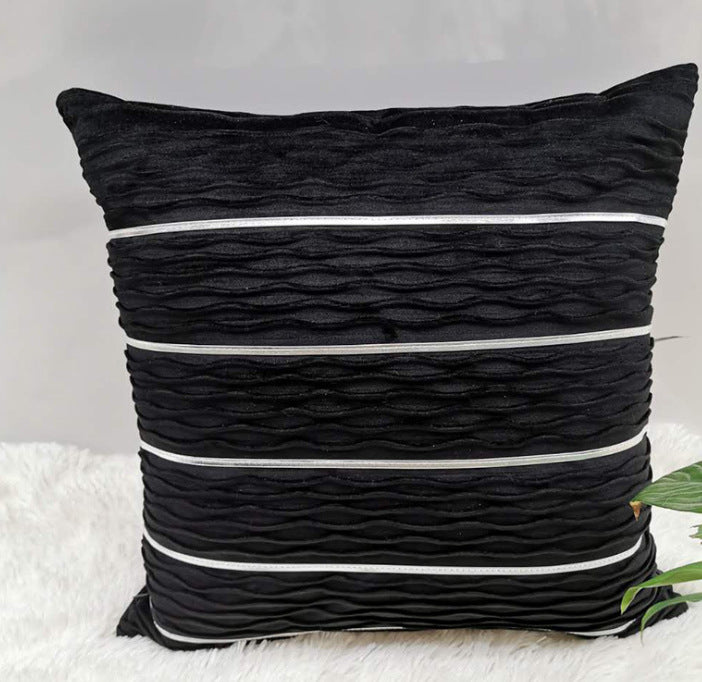Black textured pillow with white stripes on a light background