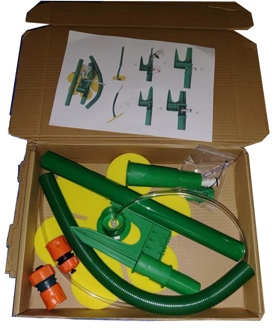 Green plumbing kit with hoses and connectors in an open cardboard box.
