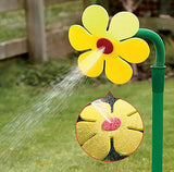 Yellow flower-shaped sprinkler spraying water on grass