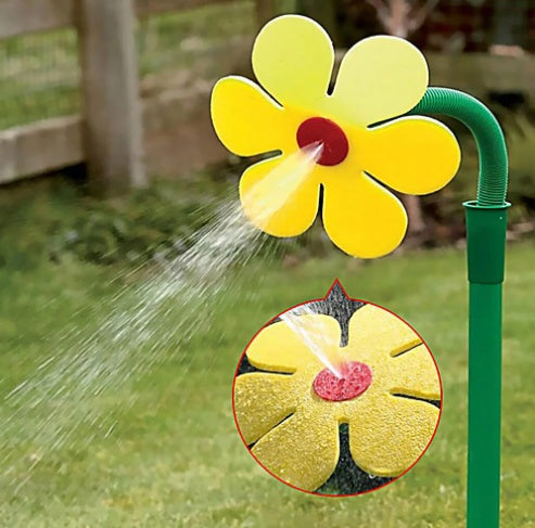 Yellow flower-shaped sprinkler spraying water on grass