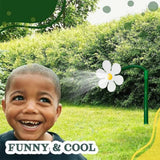 Child smiling with a flower-shaped sprinkler in a garden