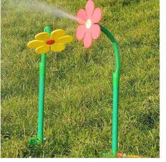 Sprinkler shaped like flowers on a grassy background