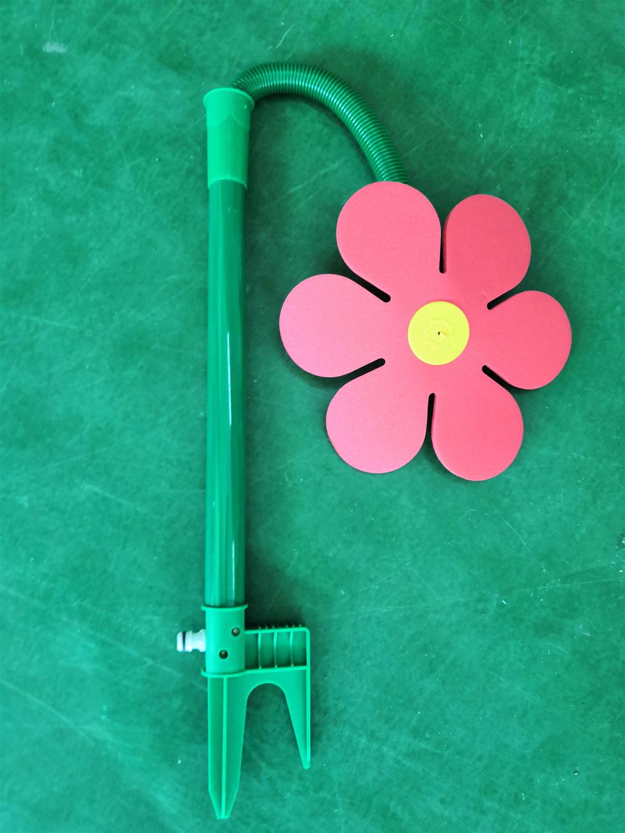 Green pool noodle with a pink flower on a green background