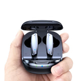 Black wireless earbuds in a charging case held by a hand on a white background