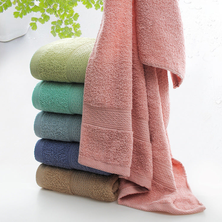 Stack of colorful towels on a white surface with green leaves in the background
