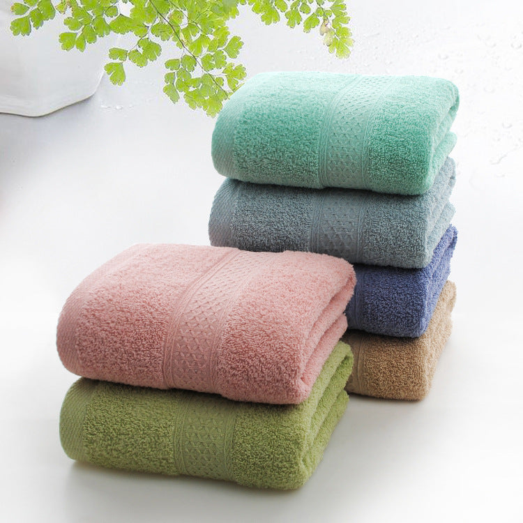 Stack of colorful towels on a white surface with green leaves in the background