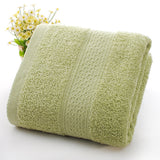 Rolled green towel with textured pattern on a white background