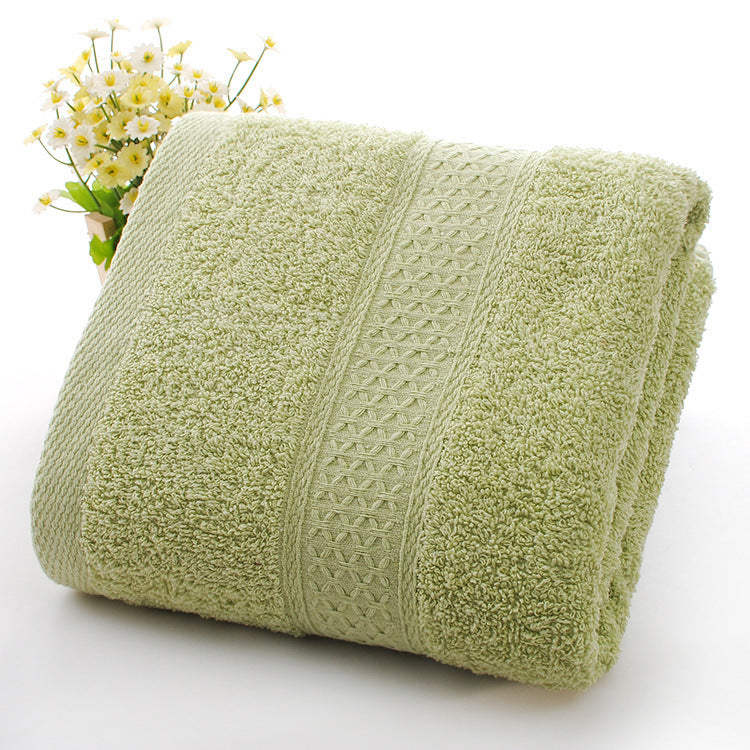 Rolled green towel with textured pattern on a white background