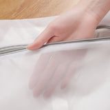 Hand opening a mesh laundry bag on a wooden surface