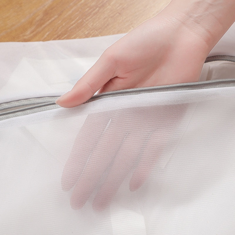 Hand opening a mesh laundry bag on a wooden surface