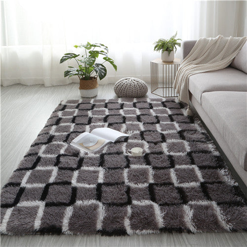 Living room with a checkered area rug, plants, and a sofa.