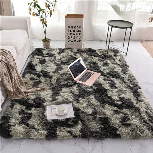 Fluffy gray rug with a laptop and tea set on a marble floor in a living room.