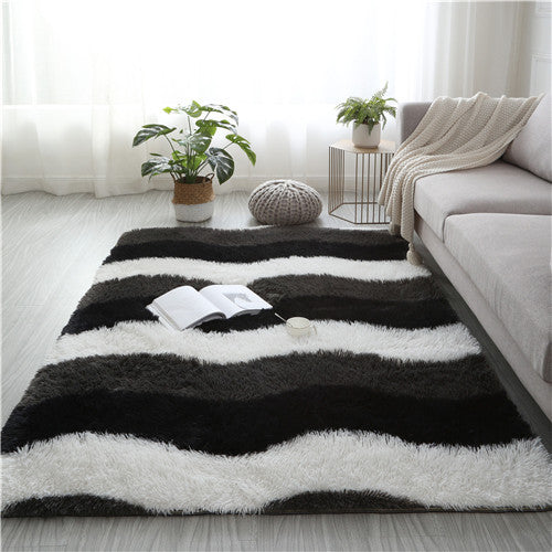 Black and white striped rug in a living room with a sofa and plants.
