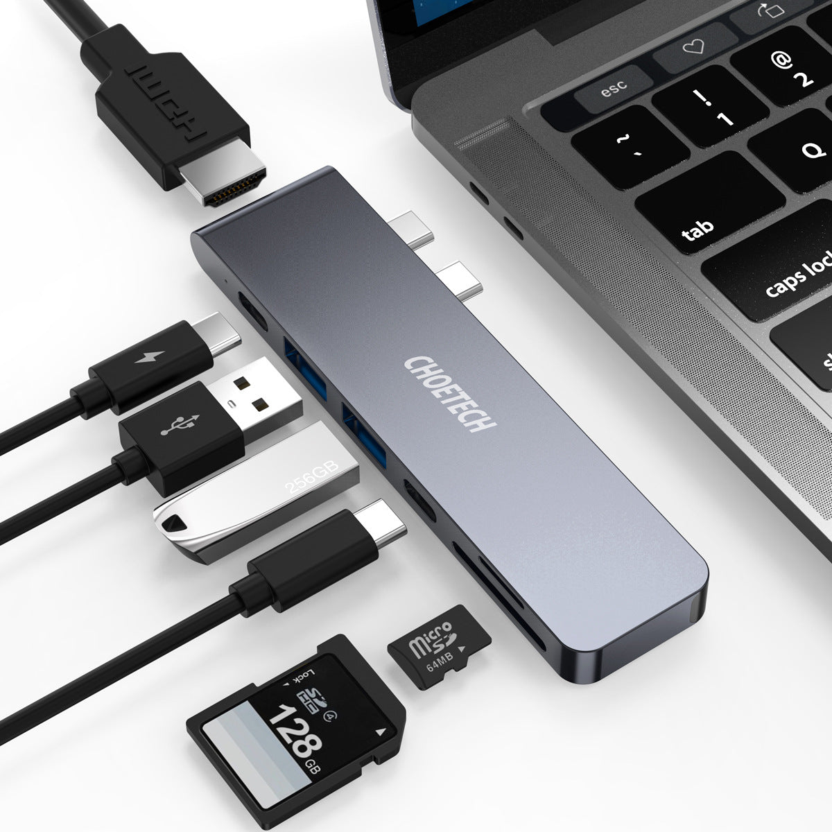 Cable organizer with USB hub, cables, and memory card in front of a laptop.