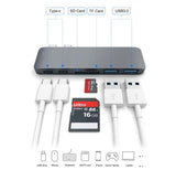 Multifunctional USB hub with various ports and cables on a white background