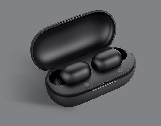 Black wireless earbuds in an open case on a gray background