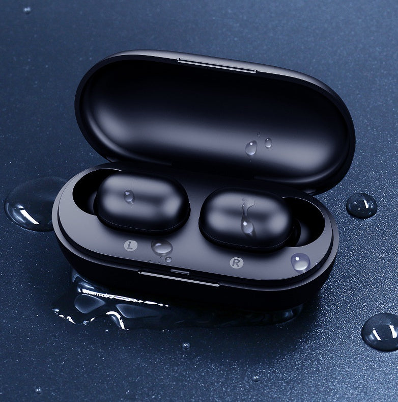 Black wireless earbuds in an open case on a dark blue background with water droplets.