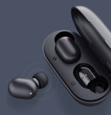 Black wireless earbuds with charging case on a dark background