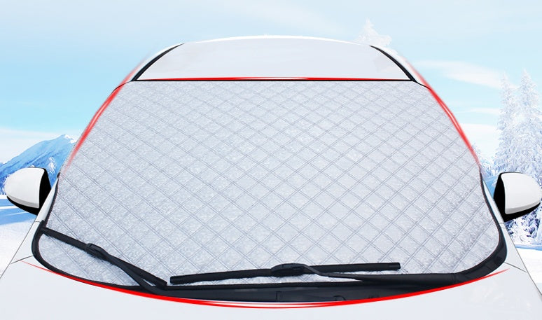 Car windshield cover with snow and ice on a car, against a snowy landscape.