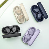 Set of wireless earbuds in various colors with their charging cases on a light green background.