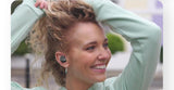 Woman wearing wireless earbuds with a blurred outdoor background