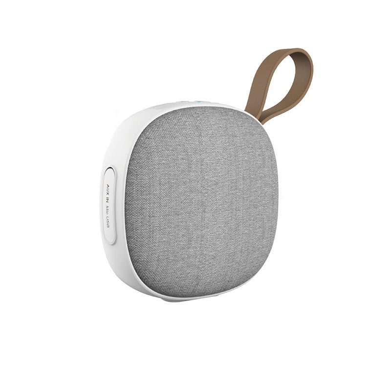 Portable speaker with a fabric cover and brown handle on a white background