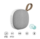 Portable speaker with gray fabric finish and white base on a white background