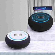 Two round black devices with wireless charging symbols on a white surface.