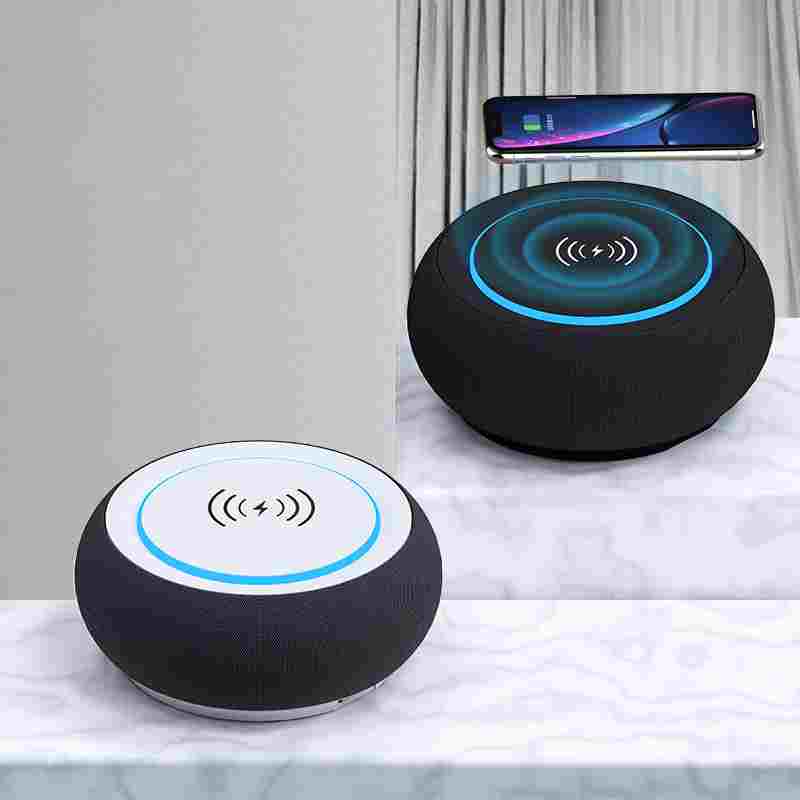 Two round black devices with wireless charging symbols on a white surface.