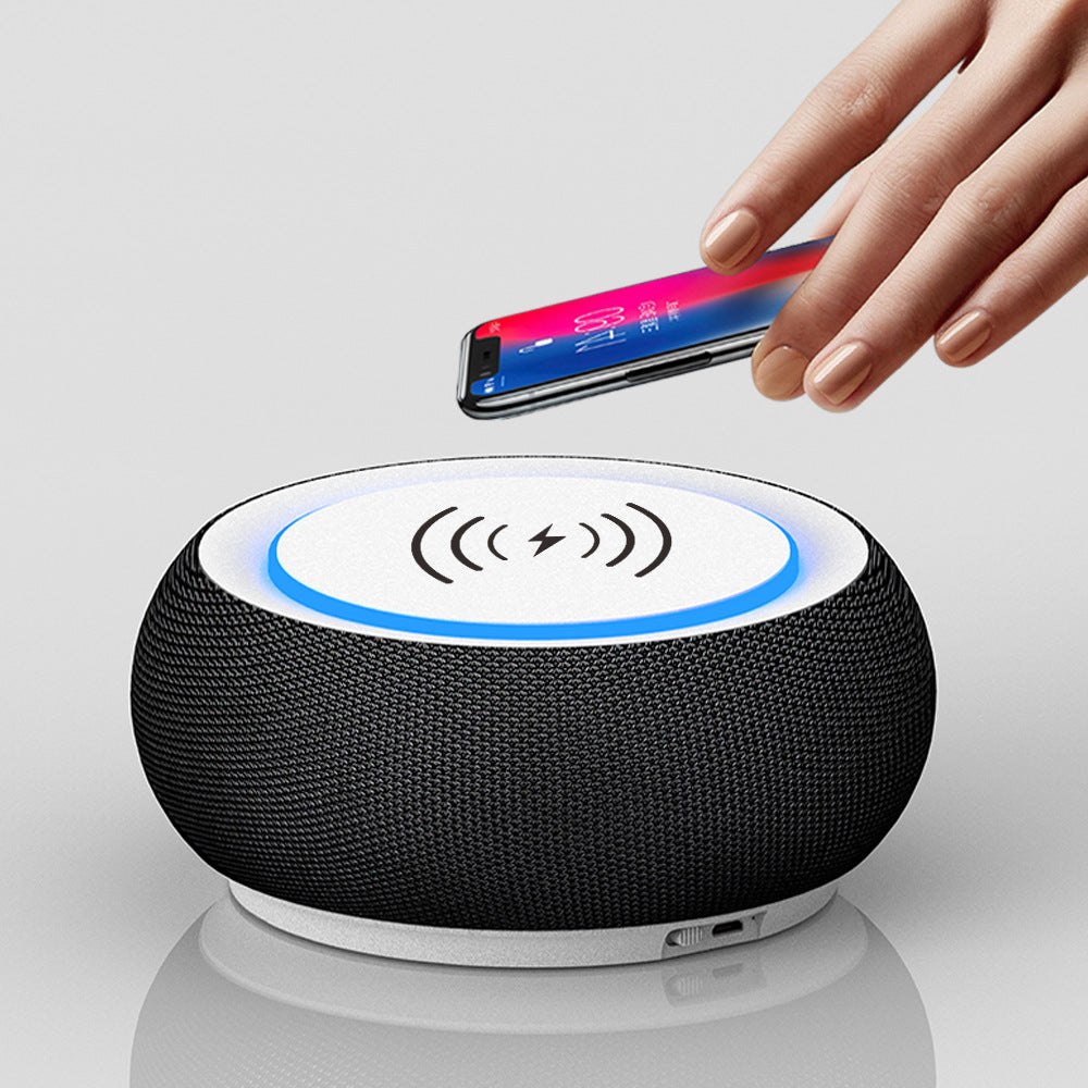 Black wireless charging pad with a hand placing a smartphone on it against a white background