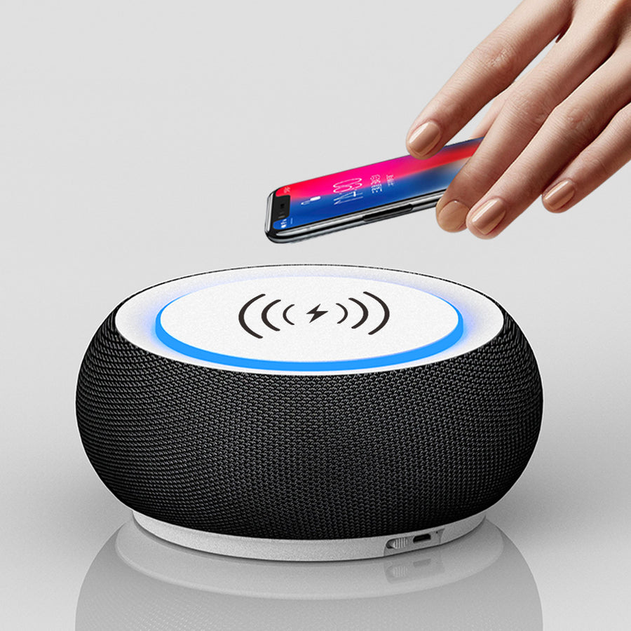 Black wireless charging pad with a hand placing a smartphone on it against a white background