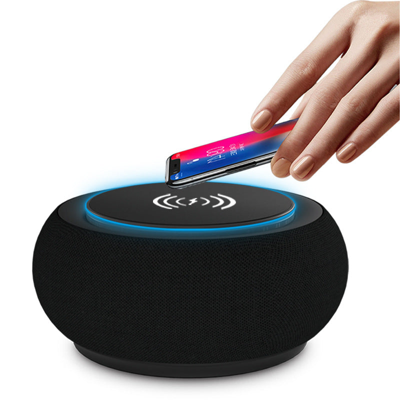 Black wireless charging pad with a hand placing a smartphone on it against a white background