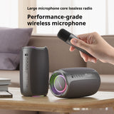 Two wireless microphones on a table with a hand holding one, in a home setting.