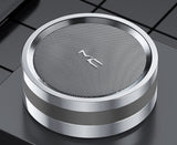 Round metallic object with a textured surface and logo on a reflective surface