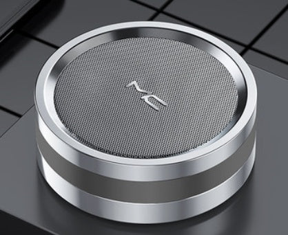 Round metallic object with a textured surface and logo on a reflective surface