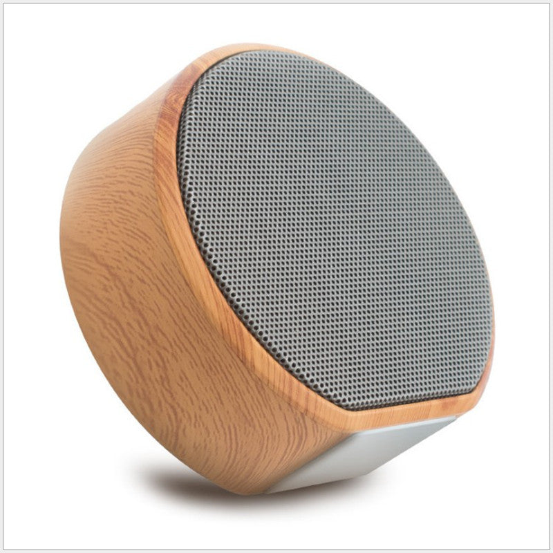 Wooden speaker with gray grille on a white background