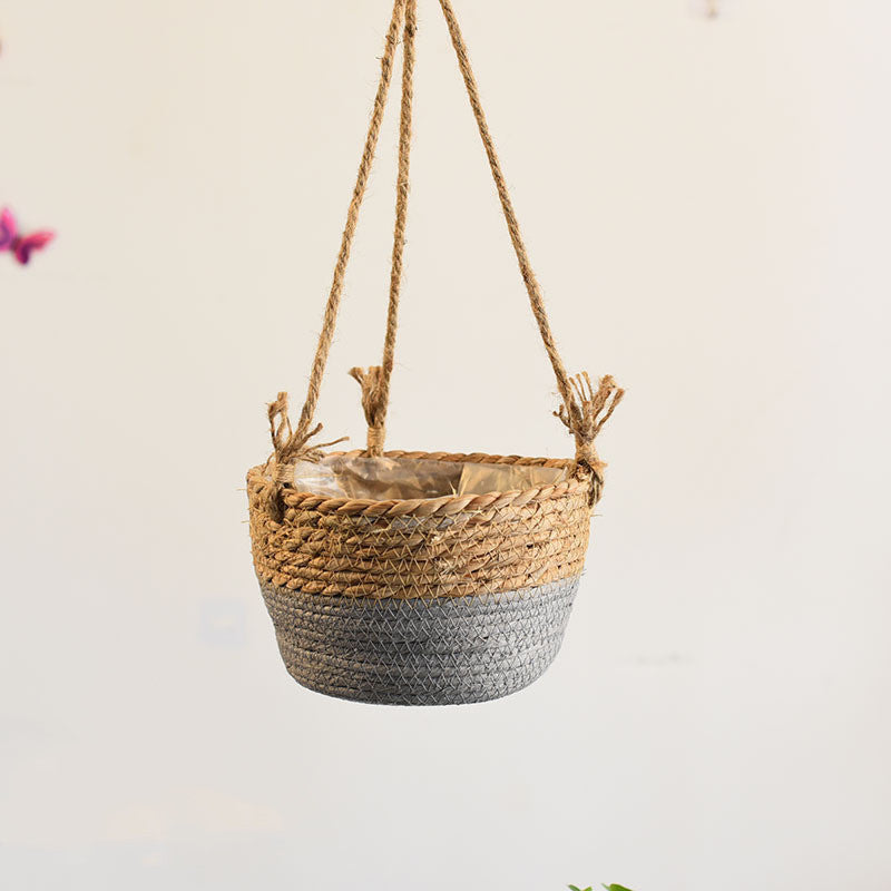 Woven hanging basket with natural and gray design on a plain background