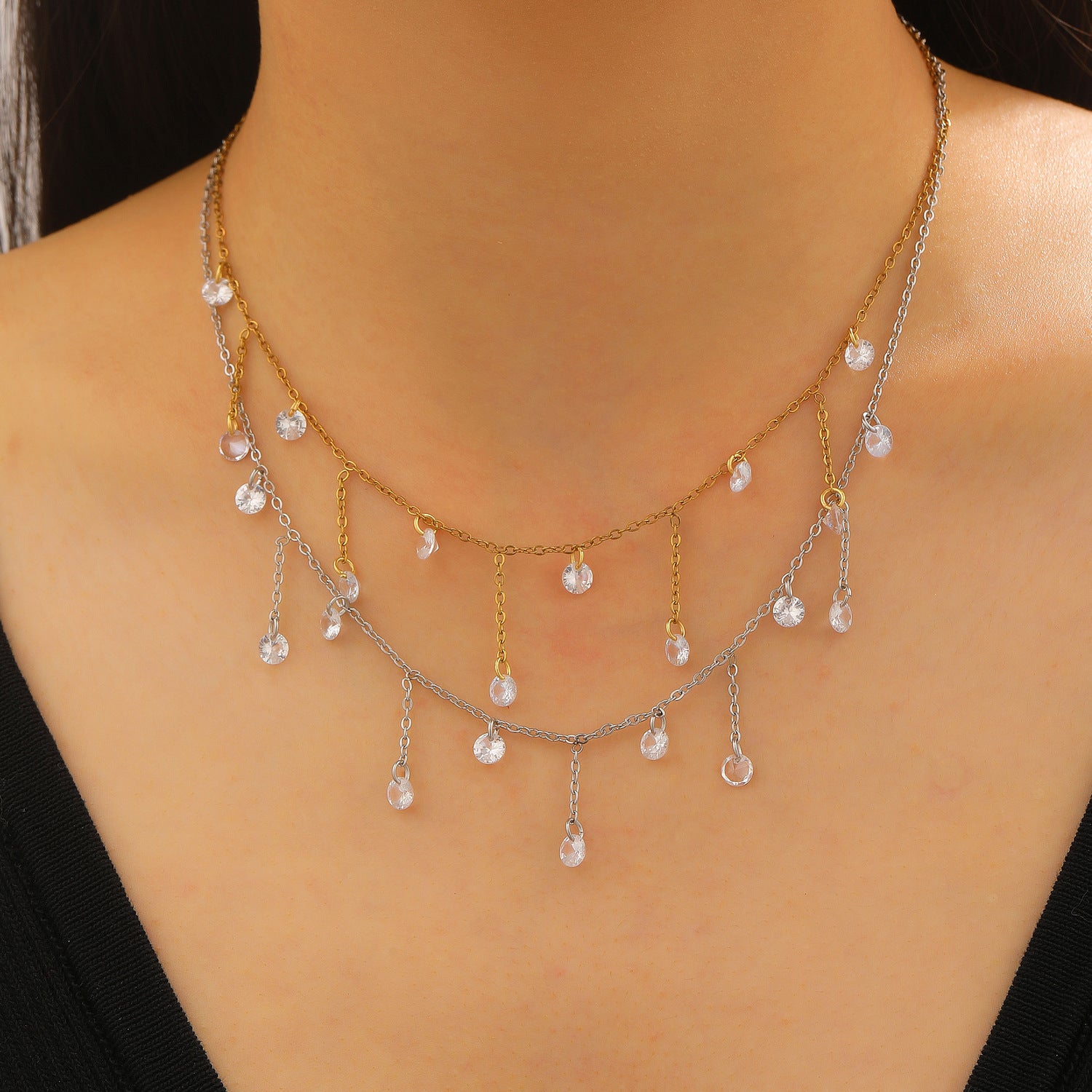 Necklace with dangling beads on a model wearing a black top