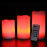 Set of three colorful LED candles with a remote control on a dark background