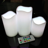 Three LED candles with a remote control on a dark surface