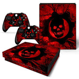 Gaming console and controllers with red and black skull design on a white background