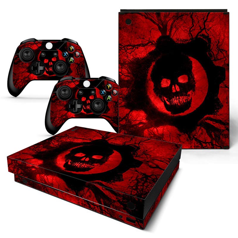 Gaming console and controllers with red and black skull design on a white background