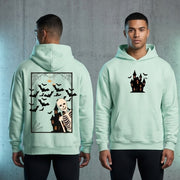 A black Essential Heavyweight Hoodie featuring a spooky skeleton leaning out of a window Halloween graphic