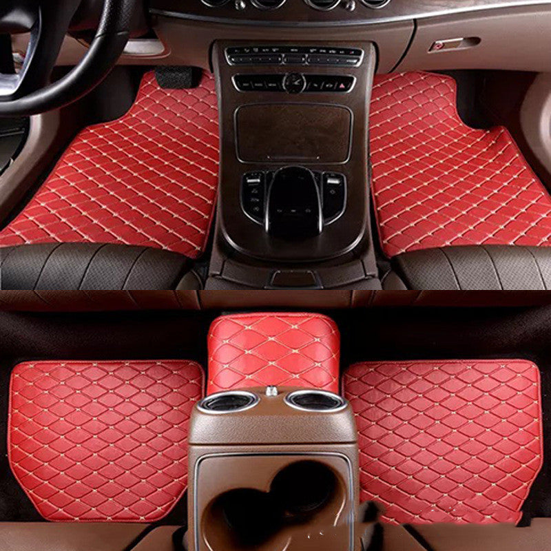 Red car floor mats with a diamond pattern on a vehicle interior.